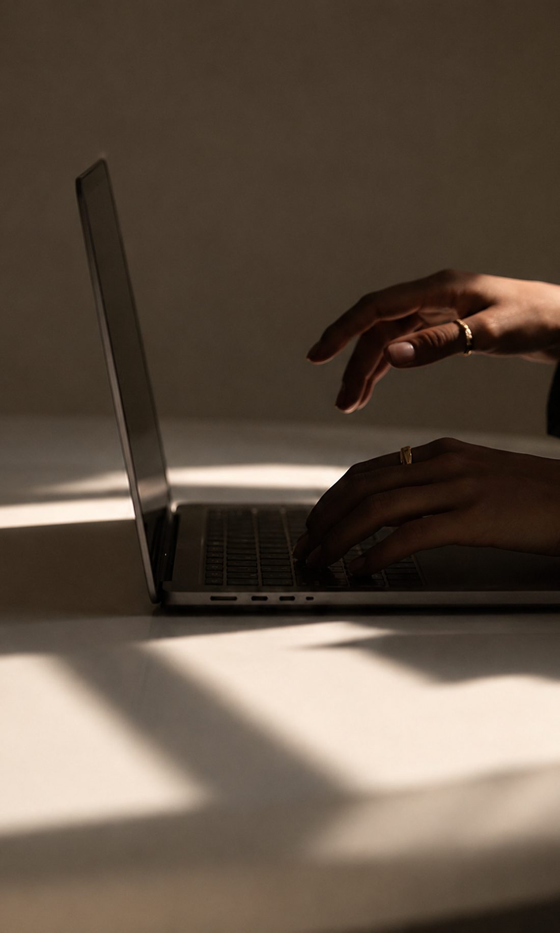 Hände an einem Laptop im Gegenlicht